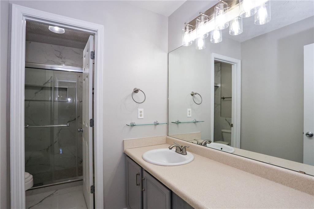 30 Emerson Trail Covington, GA 30016 - Photo 33 of 40 a bathroom with a sink vanity granite shower and a mirror