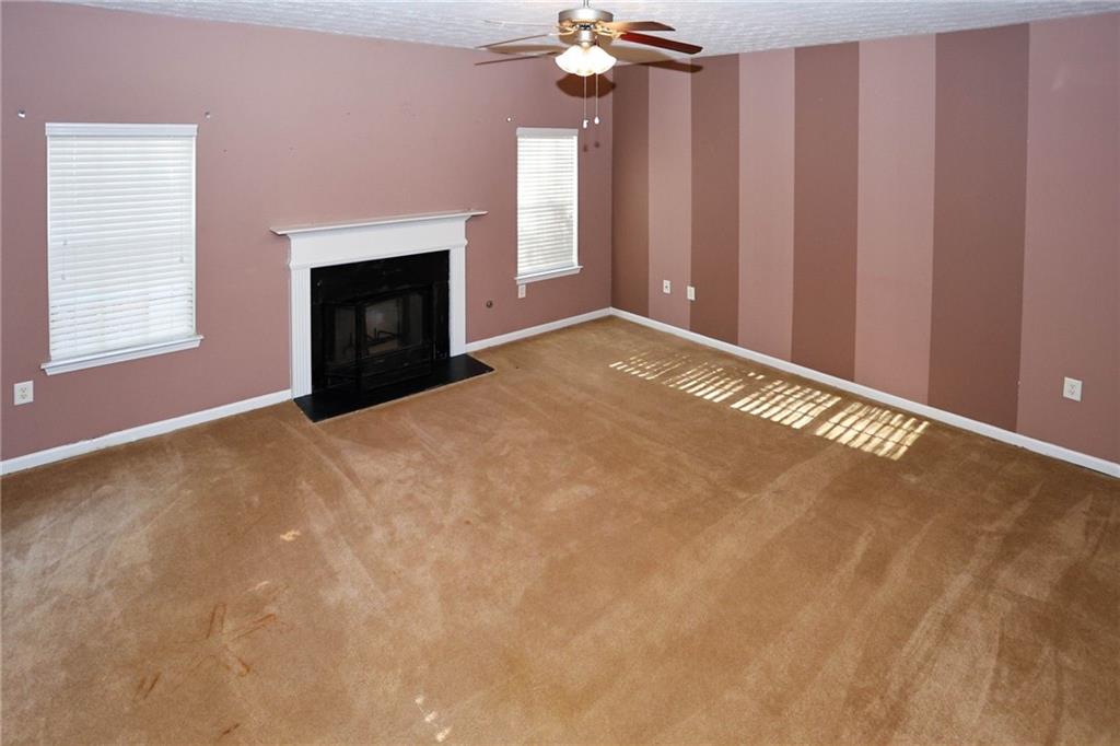 30 Emerson Trail Covington, GA 30016 - Photo 7 of 40 a view of an empty room with a fireplace and a window
