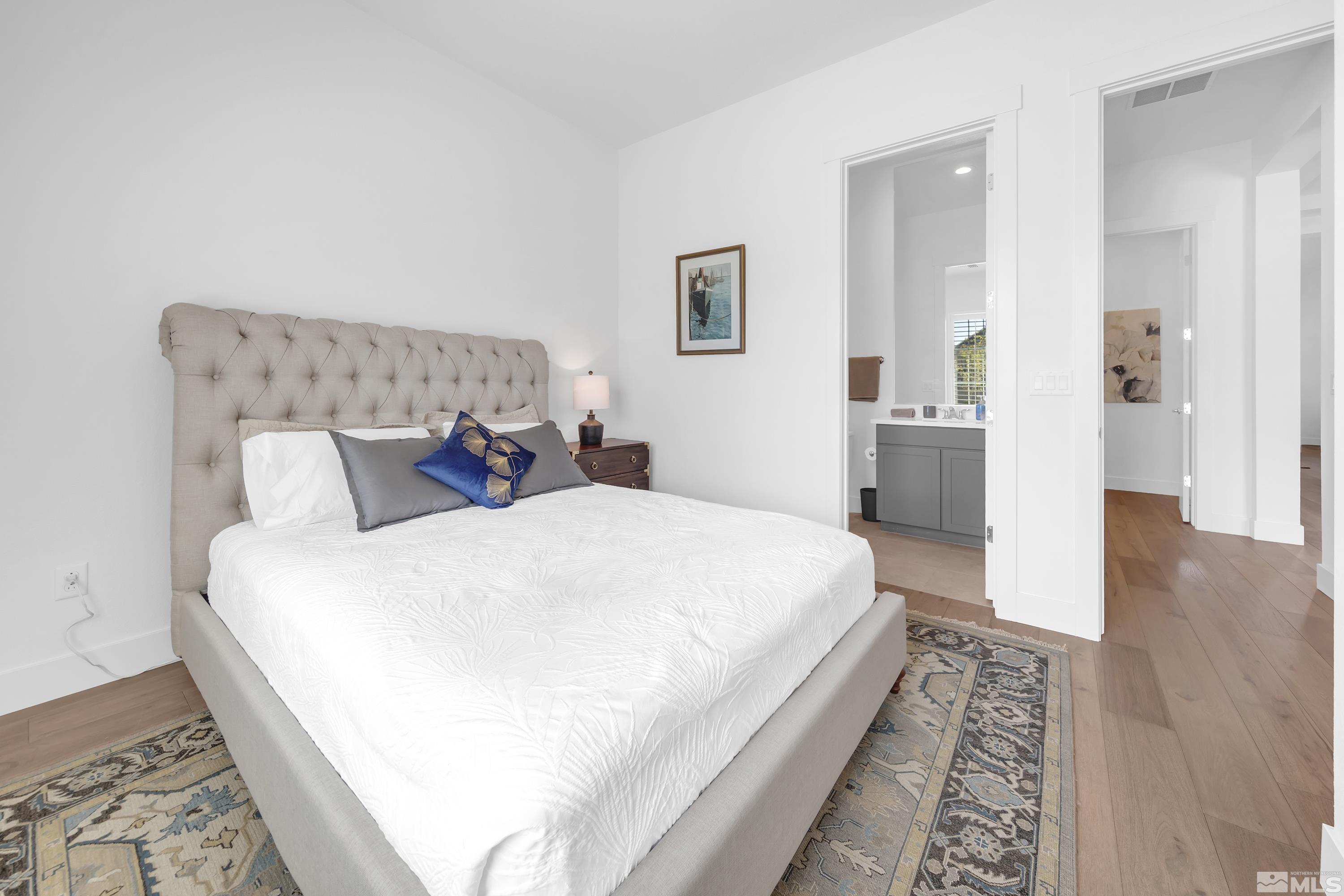 2201 Kate's Bridge Drive Reno, NV 89521 - Photo 27 of 39 a large bed sitting in a bedroom and a table