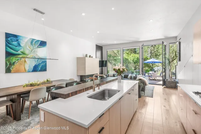 a kitchen with a sink a counter top space and living room view