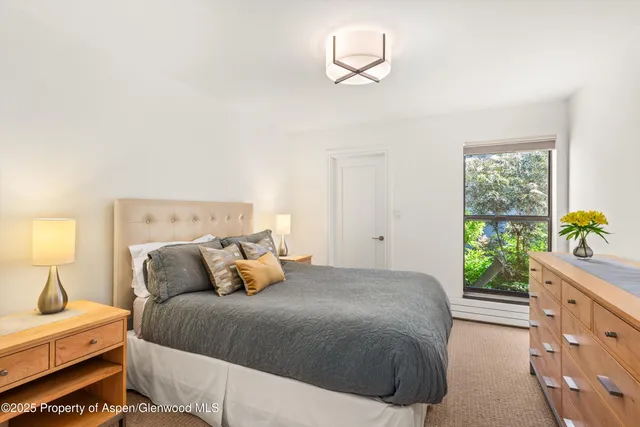 a bedroom with a bed and a lamp on dresser