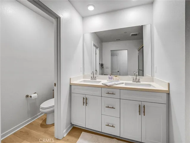 a bathroom with a granite countertop sink a toilet and a mirror