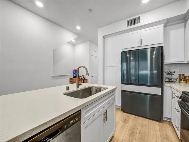 a kitchen with a sink and stainless steel appliances
