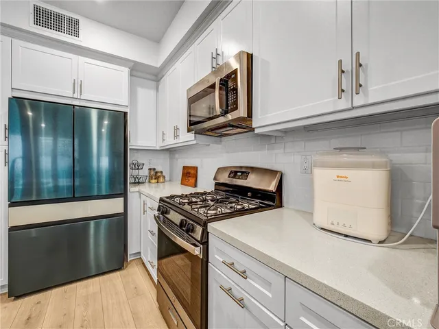 a kitchen with stainless steel appliances granite countertop a stove a microwave and a refrigerator