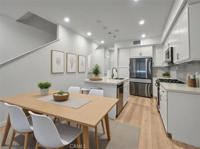 a kitchen with white cabinets and stainless steel appliances