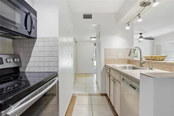 a kitchen with kitchen island a counter top space appliances and a view of living room