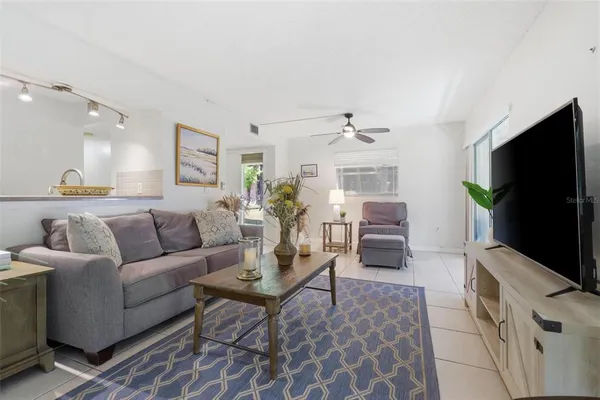 a living room with furniture and view of kitchen