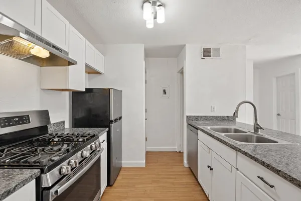 a kitchen with stainless steel appliances granite countertop a sink stove and refrigerator