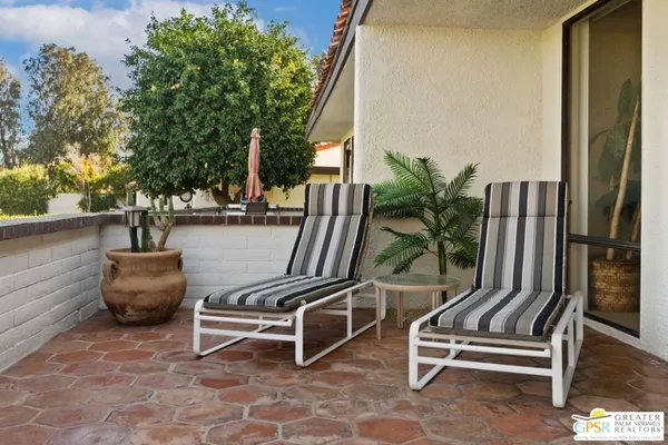 a view of a balcony and a tree front of the house