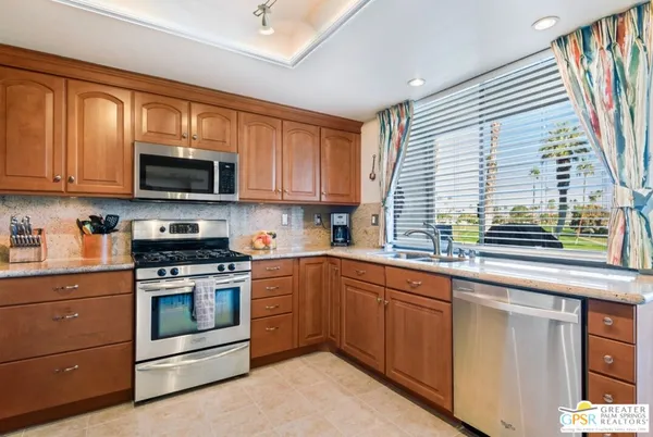 a kitchen with stainless steel appliances granite countertop a refrigerator stove and microwave