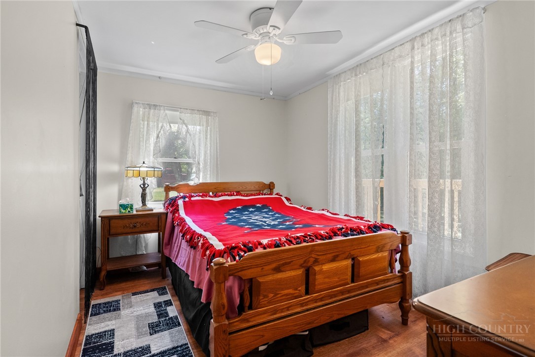 154 Folger Road Sparta, NC 28675 - Photo 12 of 37 a bedroom with a bed and a chandelier