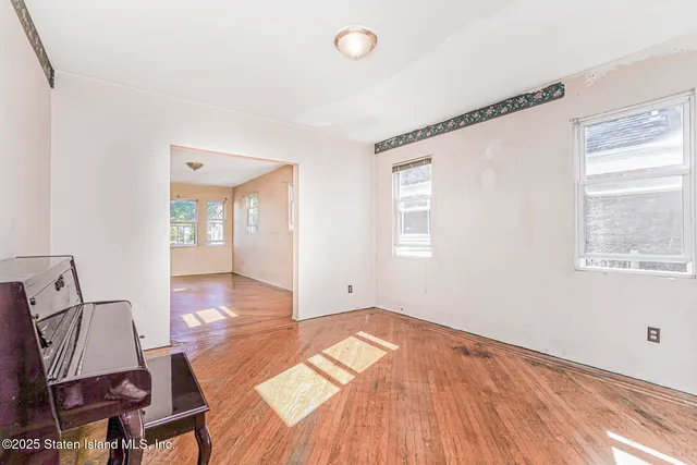 a view of a room with wooden floor and windows