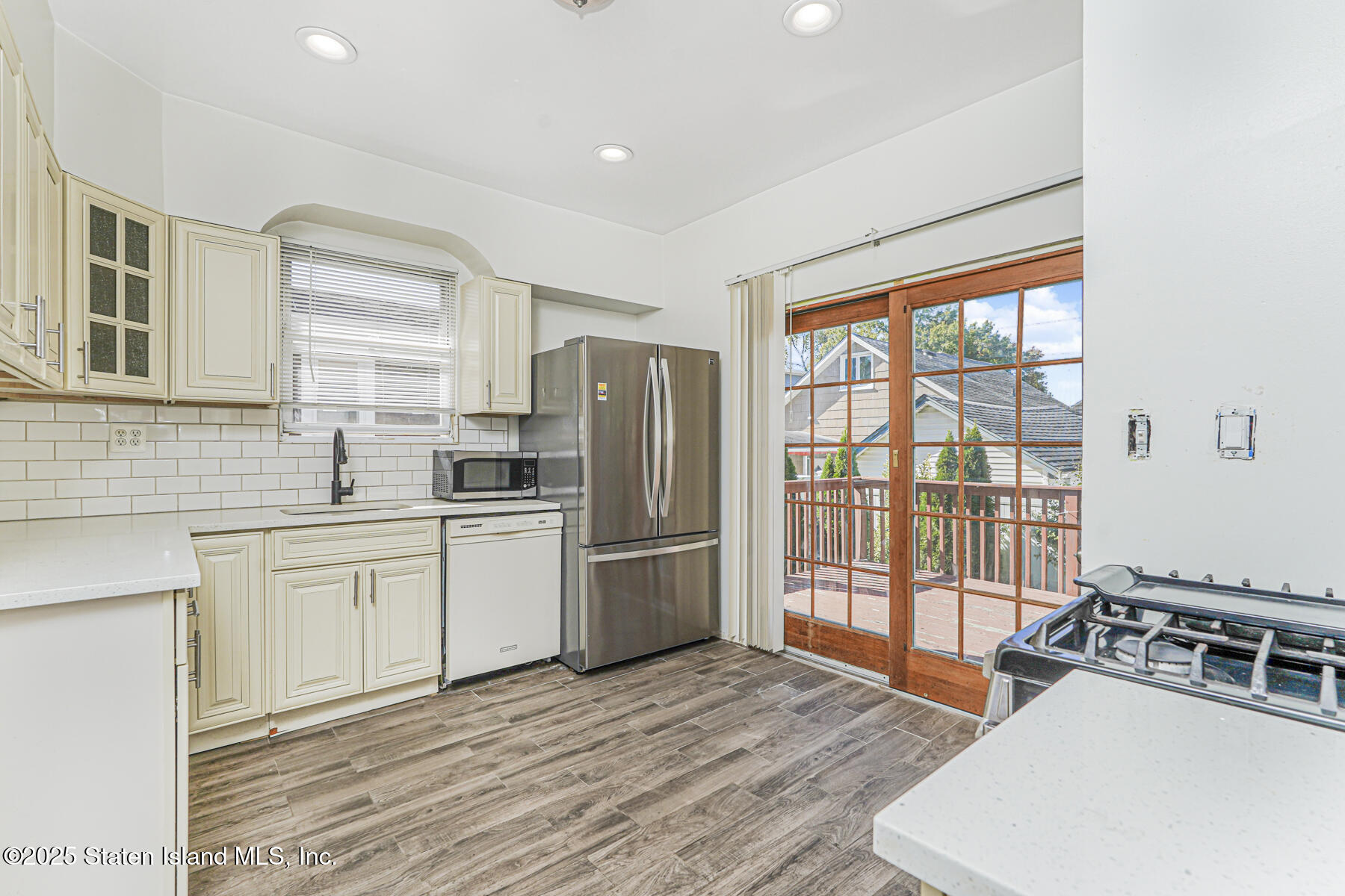 252 Dickie Avenue Staten Island, NY 10314 - Photo 17 of 37 a kitchen with stainless steel appliances granite countertop a refrigerator a stove a sink dishwasher a dining table and with wooden floor