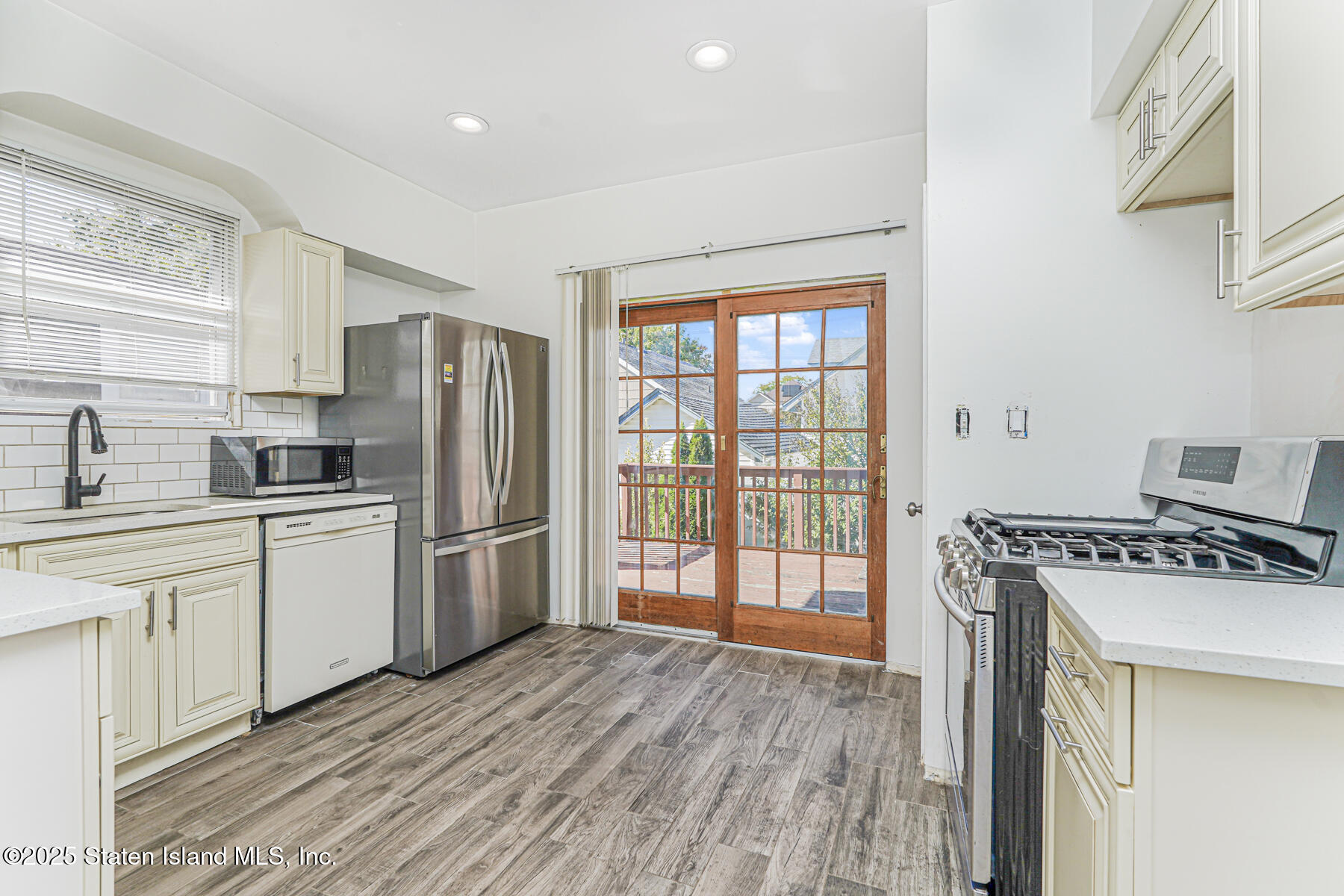 252 Dickie Avenue Staten Island, NY 10314 - Photo 18 of 37 a kitchen with a stove a sink dishwasher a refrigerator and cabinets with wooden floor