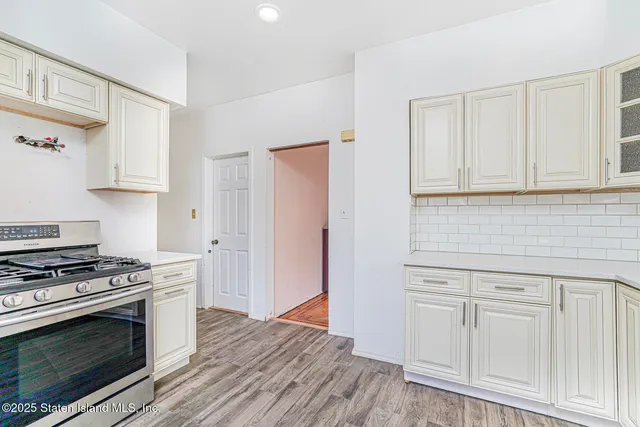 a kitchen with white cabinets and appliances