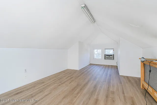 a view of empty room with wooden floor and ceiling fan