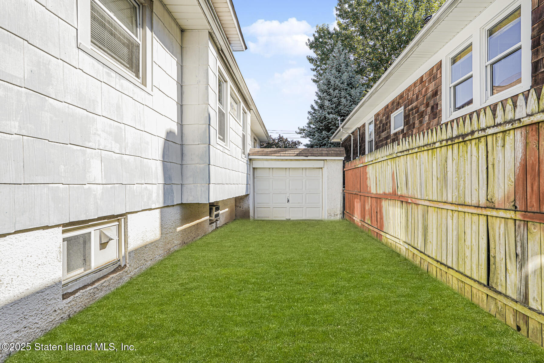 252 Dickie Avenue Staten Island, NY 10314 - Photo 34 of 37 a view of backyard with large trees and wooden fence