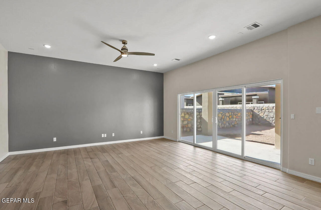 15245 Conviction Street El Paso, TX 79938 - Photo 9 of 16 an empty room with wooden floor and windows