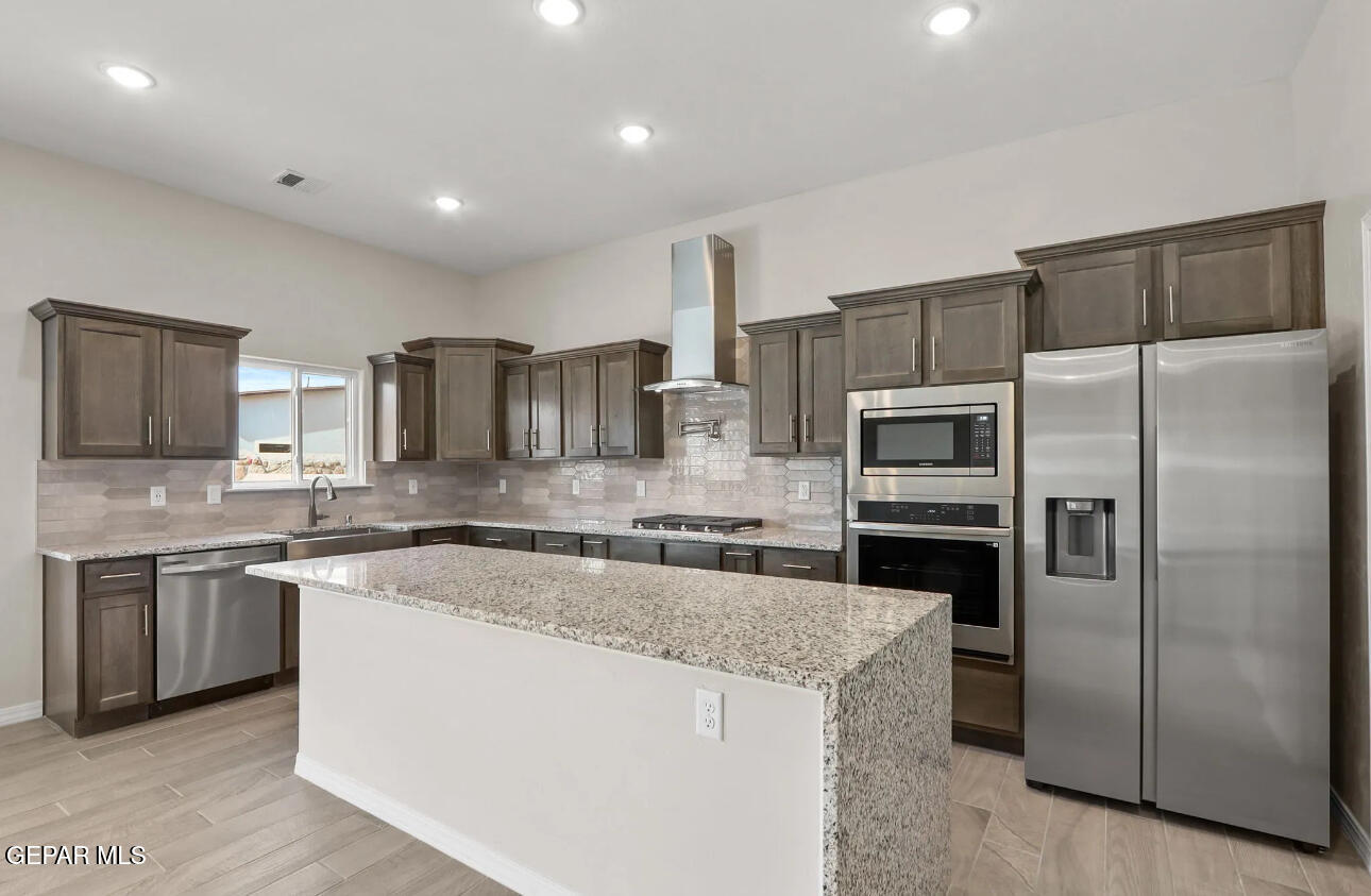 15245 Conviction Street El Paso, TX 79938 - Photo 10 of 16 a kitchen with stainless steel appliances granite countertop a sink stove refrigerator and cabinets