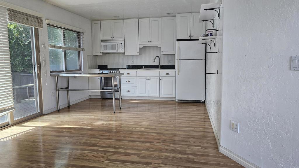 735 Avocado Court, Unit GUEST HOUS Del Mar, CA 92014 - Photo 2 of 12 a kitchen with white cabinets and stainless steel appliances