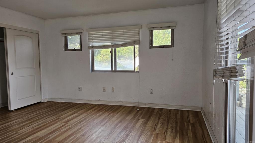 735 Avocado Court, Unit GUEST HOUS Del Mar, CA 92014 - Photo 4 of 12 an empty room with wooden floor and windows