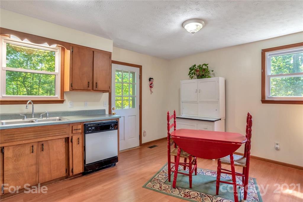 1158 Trammel Gap Road Saluda, NC 28773 - Photo 12 of 32 a kitchen with stainless steel appliances granite countertop a stove top oven a sink dishwasher and cabinets with wooden floor