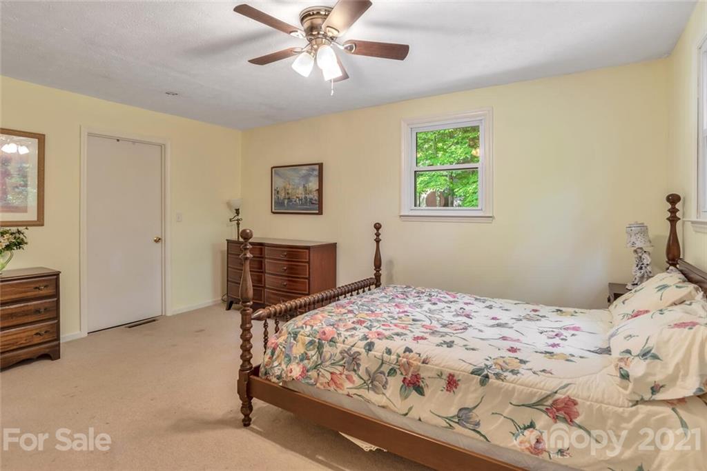 1158 Trammel Gap Road Saluda, NC 28773 - Photo 21 of 32 a bedroom with a bed and a chandelier