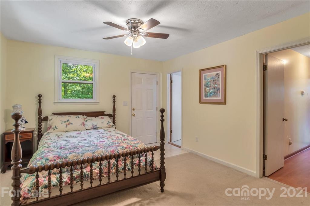 1158 Trammel Gap Road Saluda, NC 28773 - Photo 22 of 32 a bedroom with a bed and a chandelier