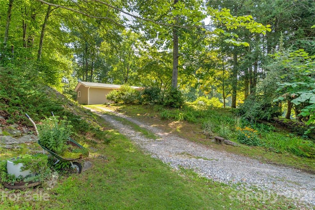 1158 Trammel Gap Road Saluda, NC 28773 - Photo 32 of 32 a backyard of a house with lots of green space and a fountain