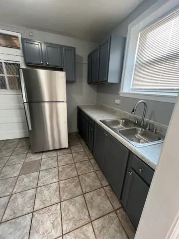 a kitchen with a sink a refrigerator and a counter top space
