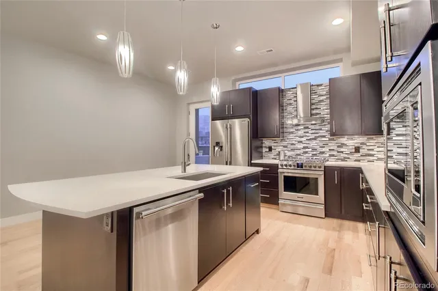 a view of a livingroom with a ceiling fan wooden floor and a ceiling fan