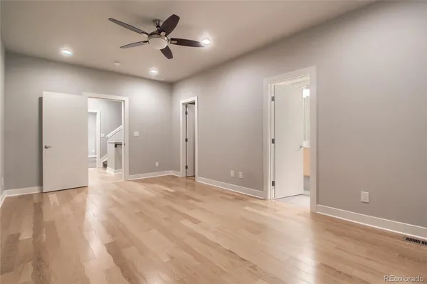 a view of a livingroom with a ceiling fan wooden floor and a ceiling fan