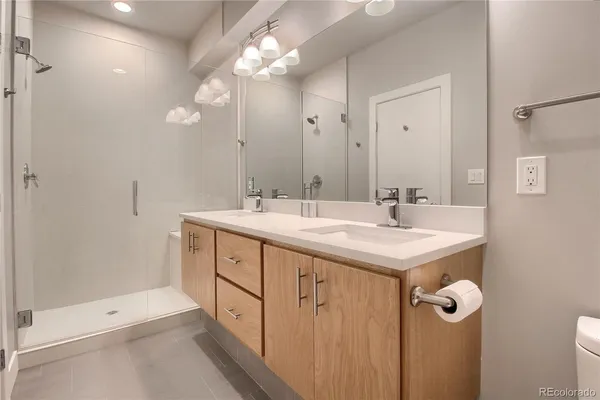 a bathroom with a shower a sink a mirror and a shower