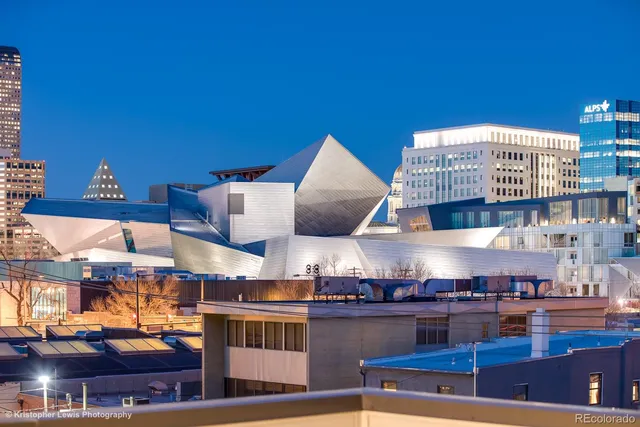 an empty room with wooden floor chandelier fan and windows