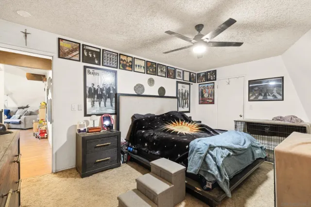 a white bed sitting in a bedroom next to a window with pc on the wall