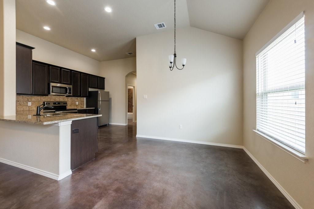 491 Jack Rabbit Lane, Unit A Buda, TX 78610 - Photo 6 of 22 A streamlined open-concept kitchen and dining area features granite countertops and stainless steel appliances.