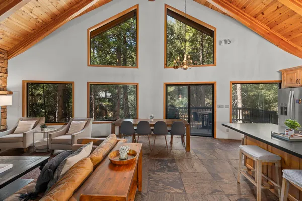 a living room with furniture large windows and wooden floor