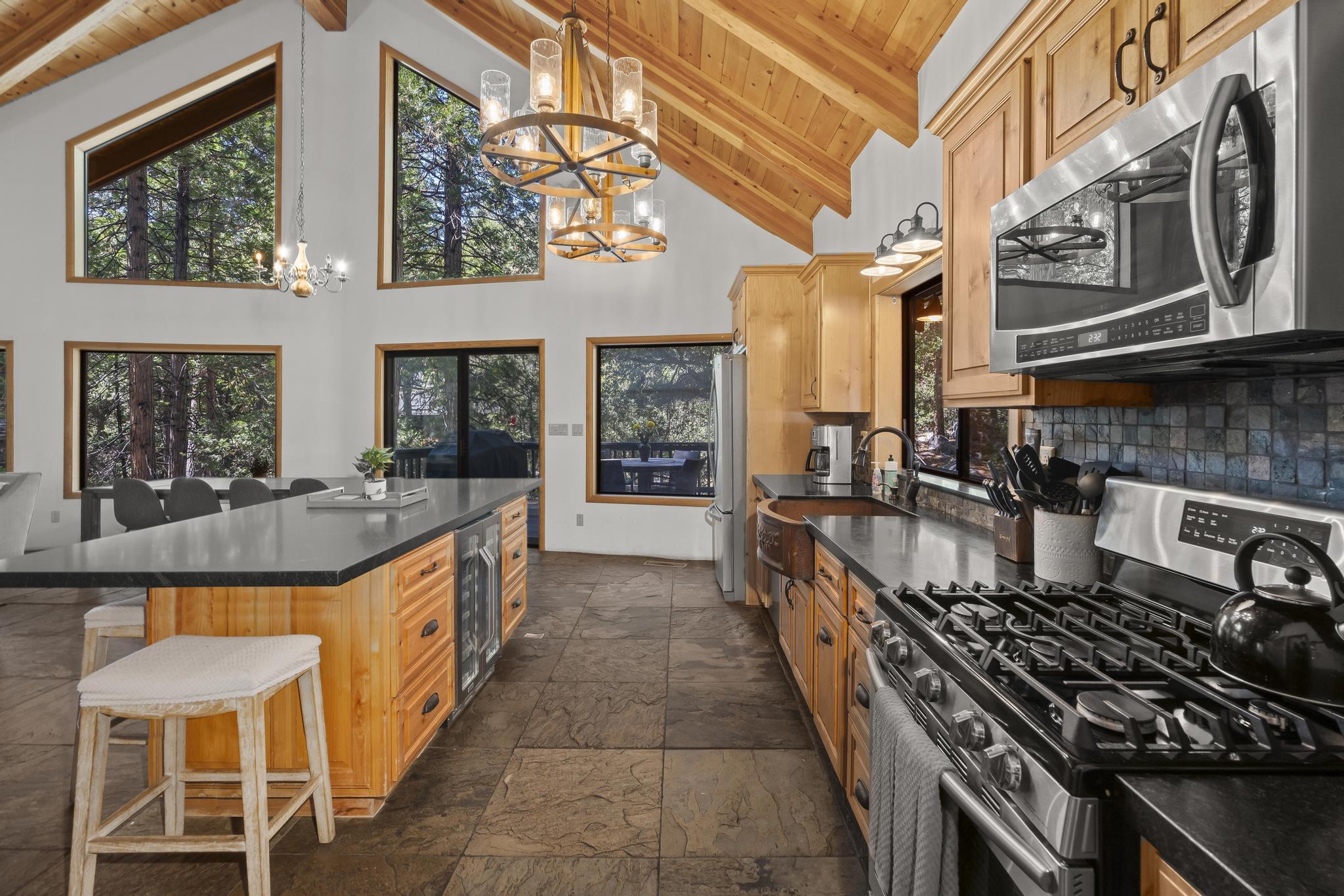 24747 Fern Valley Road Idyllwild, CA 92549 - Photo 7 of 42 a large kitchen with stainless steel appliances granite countertop a stove and a view of the house