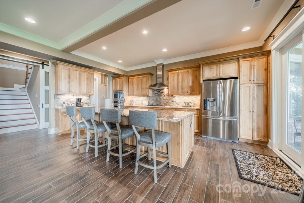 218 Queens Cove Road Mooresville, NC 28117 - Photo 26 of 42 a kitchen with stainless steel appliances a dining table chairs and wooden floor