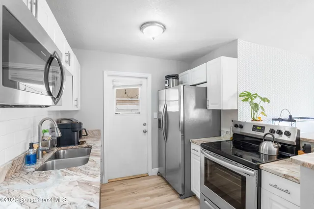 a kitchen with stainless steel appliances granite countertop a stove a refrigerator and a refrigerator