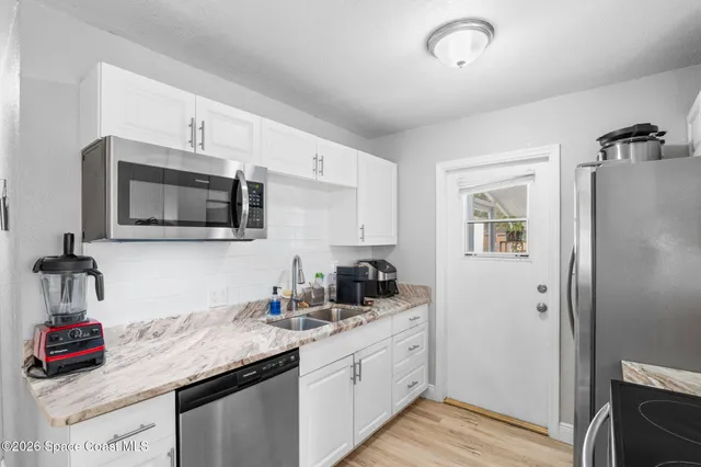 a kitchen with granite countertop a sink and cabinets