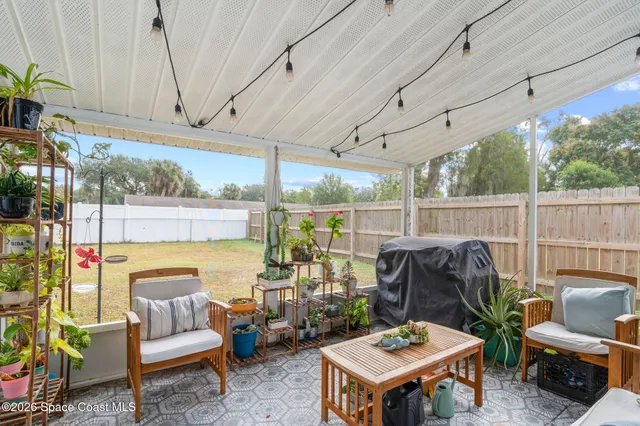 a living room with patio furniture and a floor to ceiling window