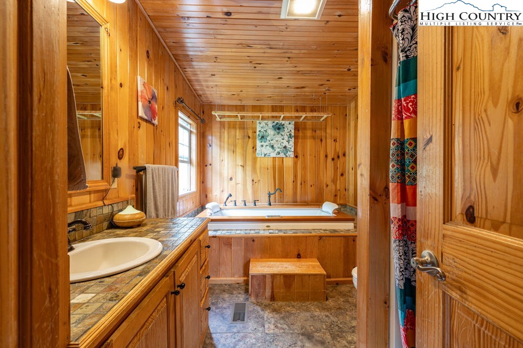 285 Roaring Fork Road Todd, NC 28684 - Photo 23 of 41 a bathroom with a granite countertop sink and a mirror