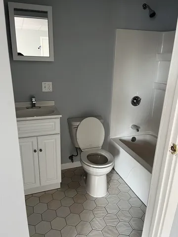 a bathroom with a toilet a sink and mirror