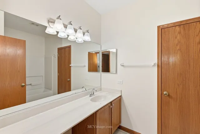 a bathroom with a sink vanity and a mirror