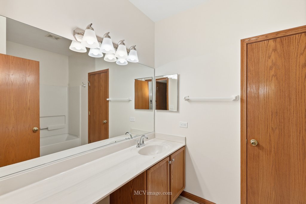 9017 Concord Lane, Unit L Justice, IL 60458 - Photo 13 of 20 a bathroom with a sink vanity and a mirror