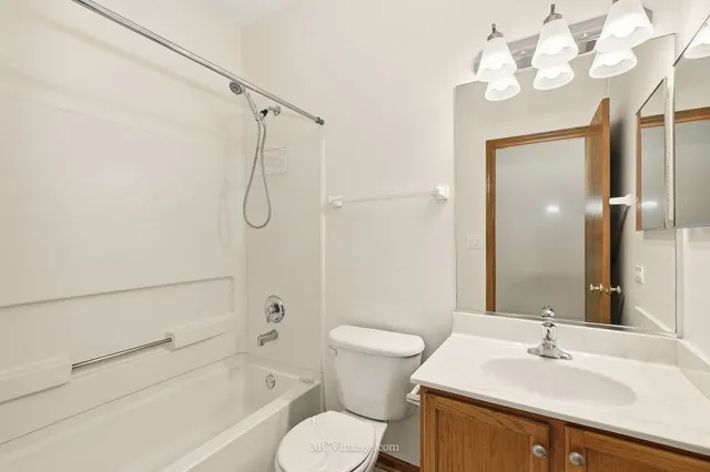 a bathroom with a sink vanity mirror and toilet