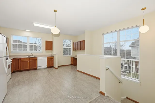 a large kitchen with stainless steel appliances a large counter top a stove a sink a window and cabinets