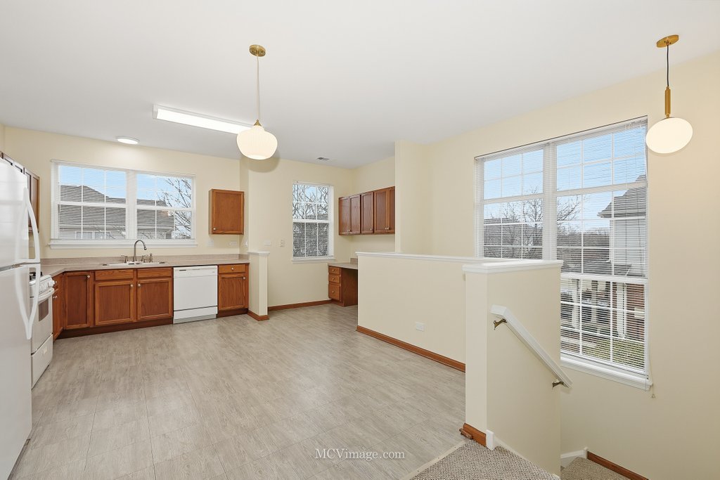 9017 Concord Lane, Unit L Justice, IL 60458 - Photo 4 of 20 a large kitchen with stainless steel appliances a large counter top a stove a sink a window and cabinets