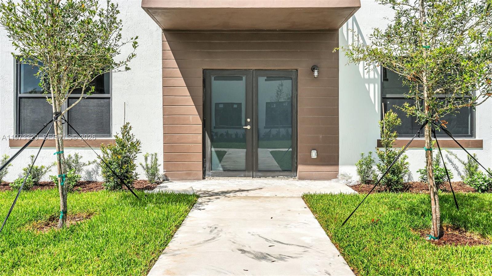 13375 Southwest 250th Street, Unit 104 Homestead, FL 33032 - Photo 1 of 27 a backyard of a house with plants and large tree